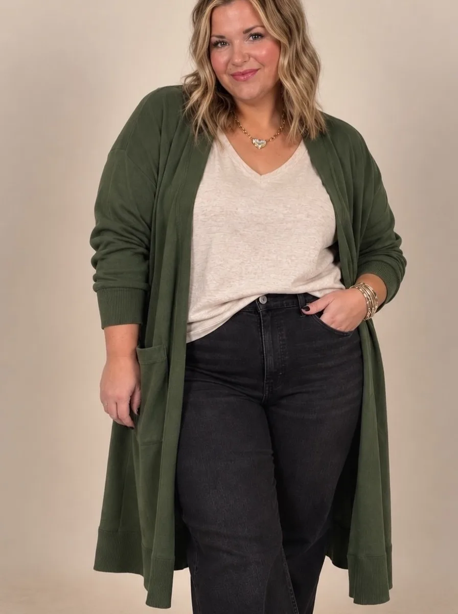Plus size woman wearing a long olive cardigan over a cream v-neck tee with black jeans